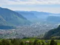 Vista panoramica di Bolzano e della valle, con montagne verdi e innevate sullo sfondo. Perfetto per scoprire cosa fare a Bolzano in un giorno.