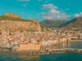 Cefalù, una delle più belle gite di un giorno da Palermo, con il suo borgo arroccato sotto la Rocca e il mare azzurro.