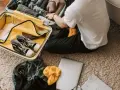Preparazione per il viaggio: cosa si può portare in aereo. Valigia aperta con scarpe, vestiti, laptop e mappa.