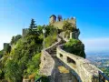 Sentiero roccioso che conduce al castello, noto come il passo delle streghe, con vista panoramica sulla valle sottostante.