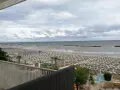 Spiaggia affollata di lettini e ombrelloni, con il mare calmo e il cielo nuvoloso. Vista dal piccadilly hotel bellaria.
