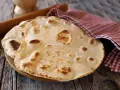 Piadine pronte per essere farcite, con un matterello e un canovaccio a quadretti. Si può fare l'impasto della piadina il giorno prima per comodità.