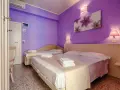 Camera accogliente con letti comodi e pareti viola, ideale per un soggiorno rilassante al Hotel Plaza Gabicce Mare.