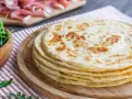 Pila di piadine marchigiane, pronte per essere farcite con rucola e salumi.