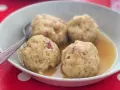 Canederli in brodo, un classico tra i piatti tipici del Trentino Alto Adige, perfetti per scoprire la curiosità culinaria della regione.