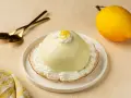 Dolce al limone, perfetto per scoprire cosa mangiare a Salerno. Servito con panna e scorzetta, pronto per essere gustato con cucchiaini dorati.