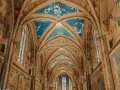 Volte affrescate con cielo stellato e scene sacre nella Basilica Superiore di San Francesco, cuore del centro storico di Assisi.