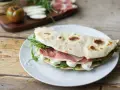 Piadine particolari con prosciutto crudo, mozzarella e rucola, un classico romagnolo pronto per essere gustato.