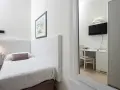 Accogliente camera singola hotel con letto, scrivania e TV visibili nello specchio.