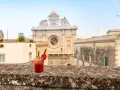 Cocktail rosso con fragola e menta, sullo sfondo la Basilica di Santa Croce. Il miglior aperitivo a Lecce.