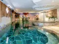 Piscina interna con cascata e decorazioni naturali, un'oasi di relax all'Hotel Sporting Andalo.