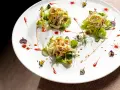 Tre porzioni di insalata di pollo e verdure su un piatto bianco, un'ottima opzione per trattorie economiche a Bra.
