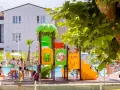 Bambini giocano in piscina e su uno scivolo colorato, un'immagine che riflette le positive recensioni di Color Perla Village.