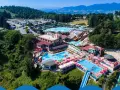 Un grande parco acquatico nelle Marche, con scivoli, piscine e tante persone che si divertono sotto il sole.
