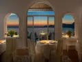 Tavoli apparecchiati nel ristorante dell'hotel Tramonto d'Oro, con vista sul mare al tramonto.