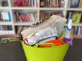 Secchio verde con accessori per la pulizia: rotolo di carta, panni, spruzzino, spugna. Ideale per sapere cosa portare in camper per un viaggio pulito.