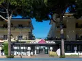 Hotel Roma Cesenatico, con pini marittimi e arredi esterni moderni, invita al relax.