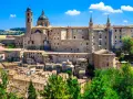 Urbino, con il suo imponente Palazzo Ducale, è un punto strategico per visitare le Marche, offrendo scorci mozzafiato e storia.