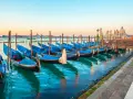 Gondole blu ormeggiate a Venezia, un modo suggestivo per muoversi spendendo poco.
