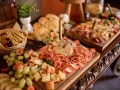 Un ricco buffet con salumi, formaggi, frutta e pane, un vero banchetto che fa pensare alla pensione completa significato: tutto incluso per godersi il momento.