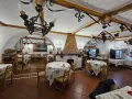 Interno di un ristorante con tavoli apparecchiati e un camino decorato. Un'ottima opzione per sapere dove mangiare a Potenza.