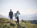 Coppia escursionista sorridente in montagna. L'aria di montagna fa bene al raffreddore, rigenera corpo e mente.