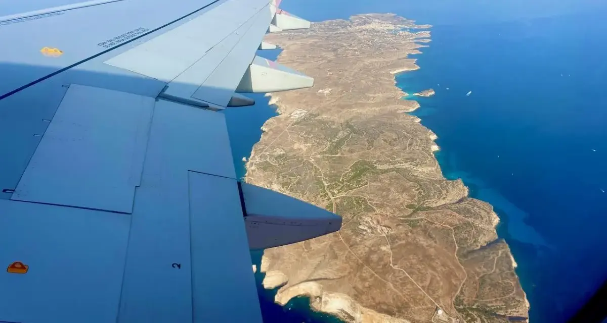 Vista aerea di Lampedusa dall'aereo, con l'ala in primo piano. Un modo per capire come arrivare a Lampedusa.