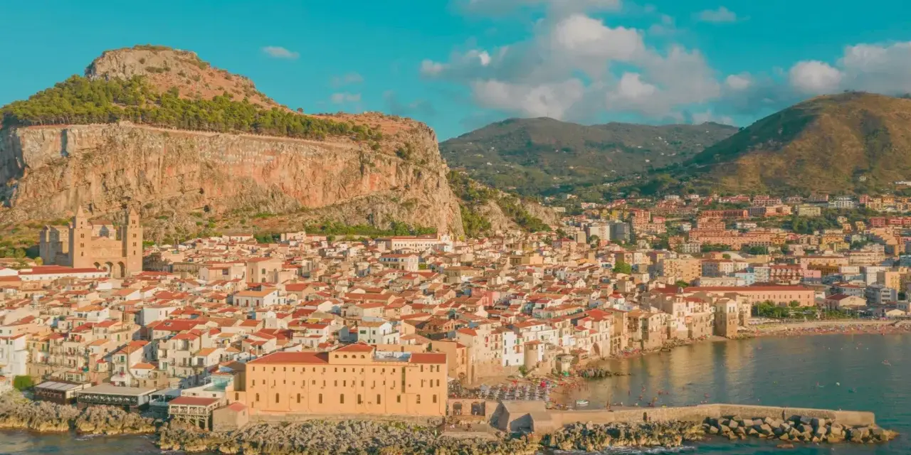 Cefalù, una delle più belle gite di un giorno da Palermo, con il suo borgo arroccato sotto la Rocca e il mare azzurro.