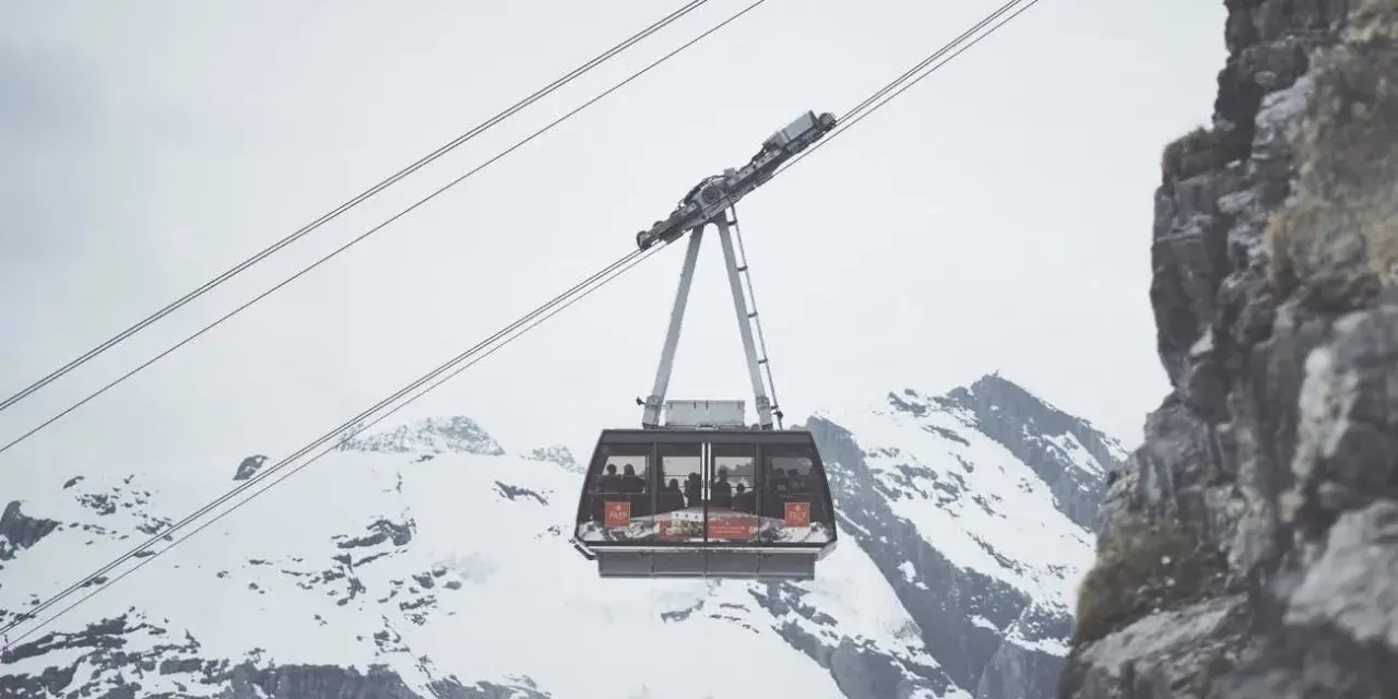 Cabina della funivia in Trentino, sospesa tra cime innevate e rocce imponenti, ideale per muoversi in un paesaggio mozzafiato.