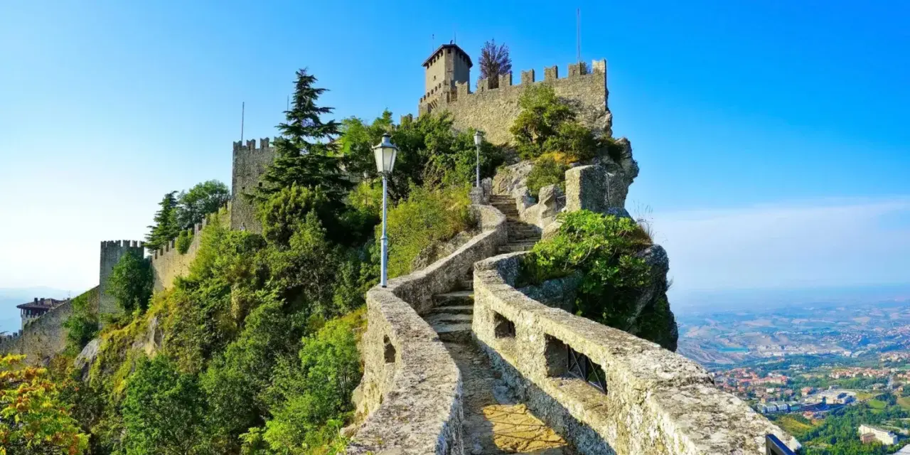 Sentiero roccioso che conduce al castello, noto come il passo delle streghe, con vista panoramica sulla valle sottostante.