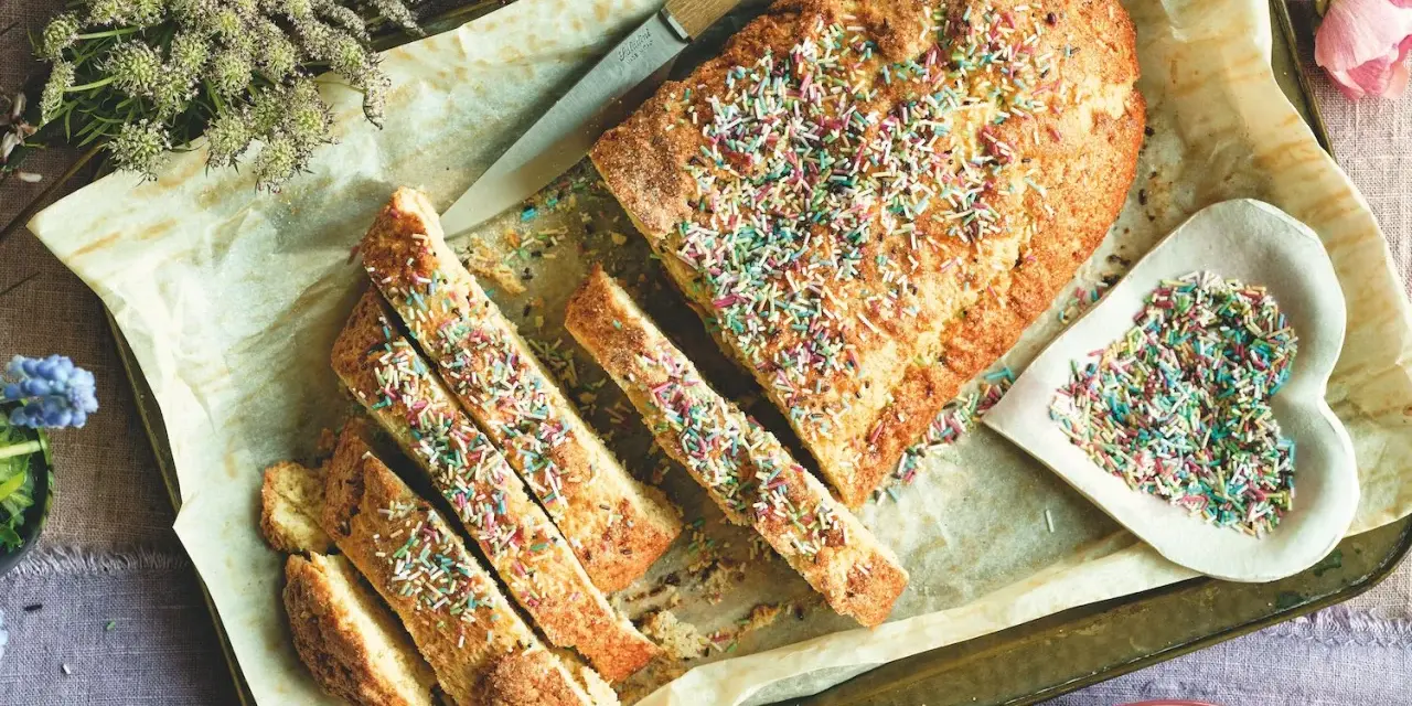 Dolce tipico romagnolo, un ciambellone soffice decorato con zuccherini colorati, pronto per essere gustato.