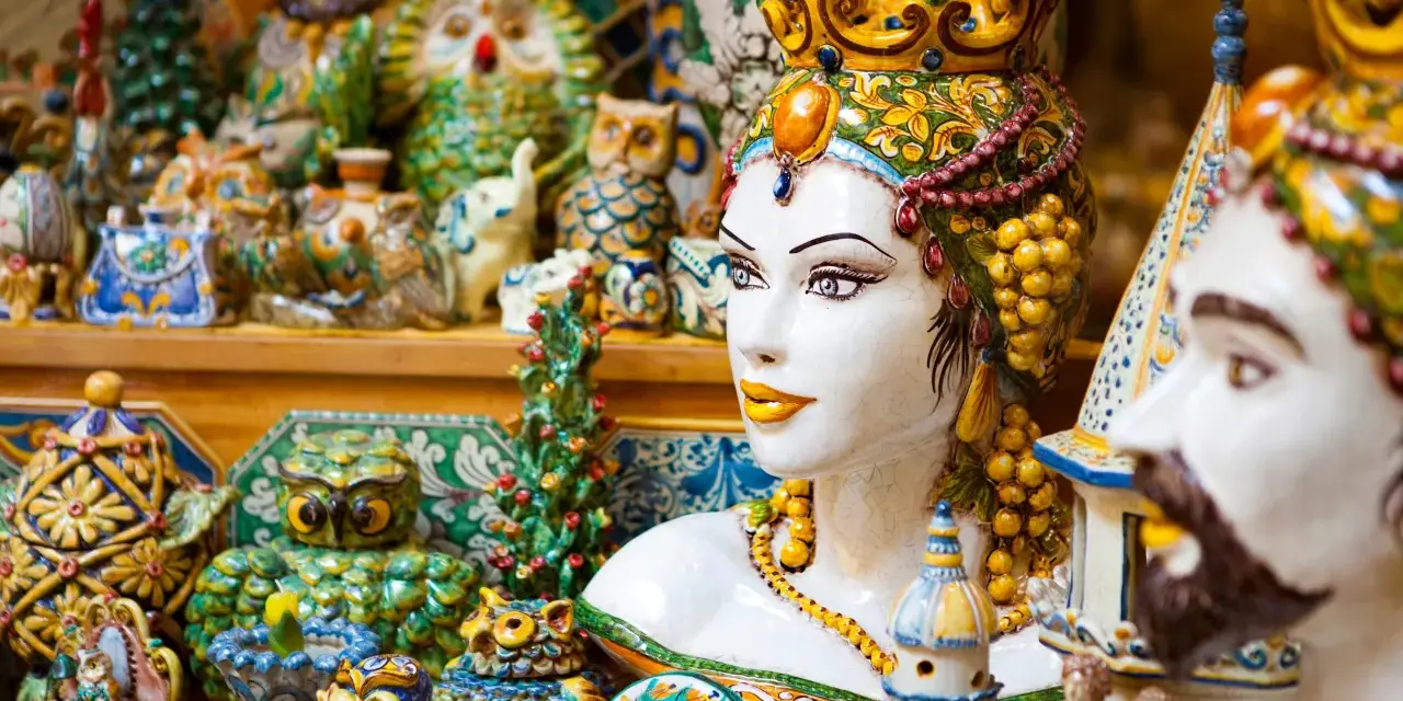 Ceramiche colorate, gufi, teste di moro e vasi: un tripudio di souvenir di viaggio che cattura l'essenza dell'artigianato locale.