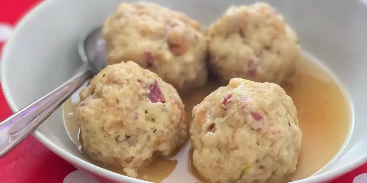Canederli in brodo, un classico tra i piatti tipici del Trentino Alto Adige, perfetti per scoprire la curiosità culinaria della regione.