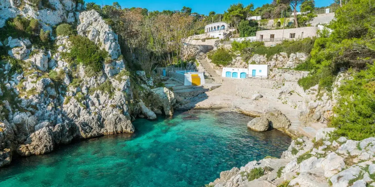 Baia con acque cristalline e case bianche, perfetta per un tour della Puglia in 5 giorni.