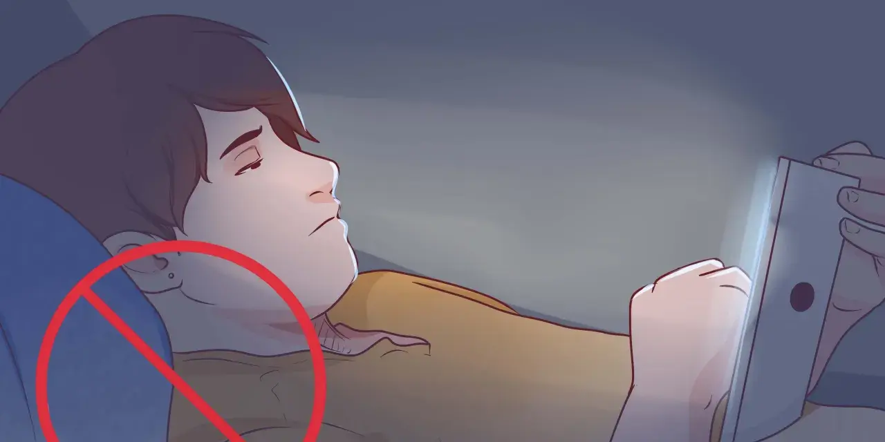 Ragazzo sdraiato al buio, illuminato da uno schermo, con un cerchio rosso di divieto sull'orecchio. Evita di dormire fuori casa con il telefono.