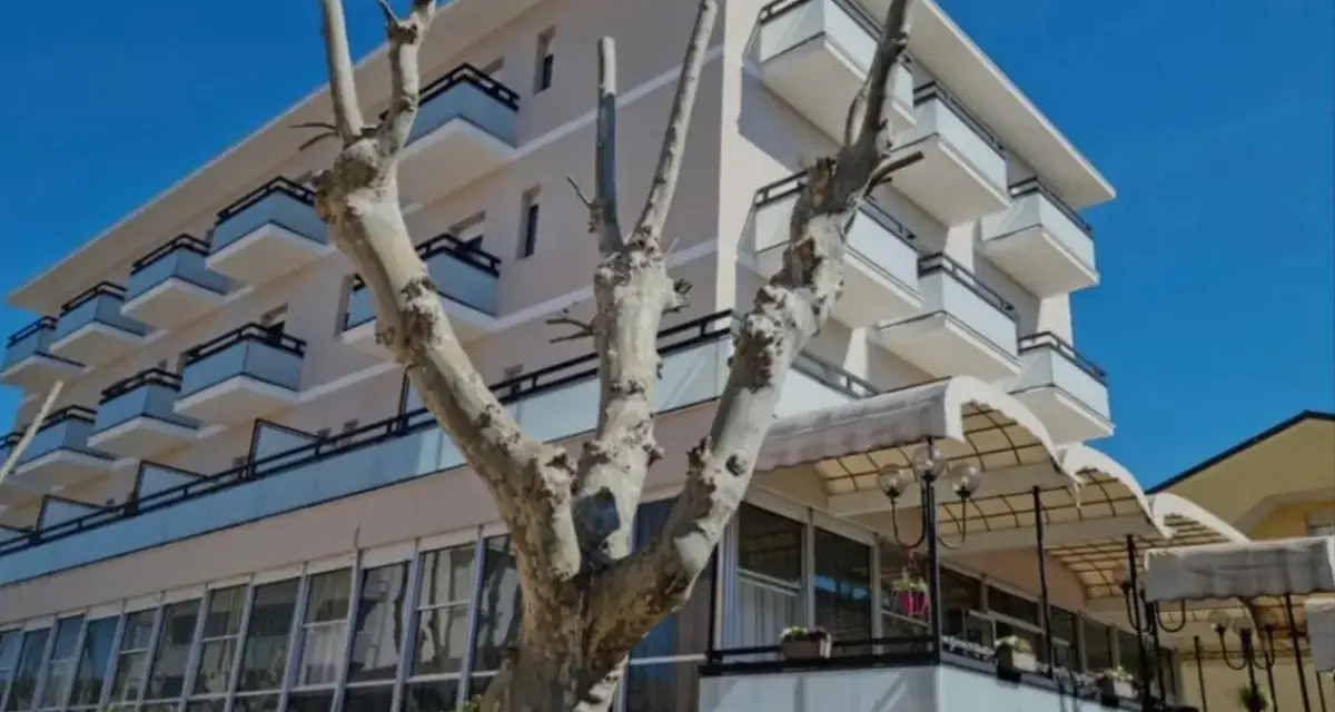 Edificio moderno con balconi e vetrate, un albero spoglio in primo piano. Il **Kursaal Bellaria** si presenta sotto un cielo azzurro.