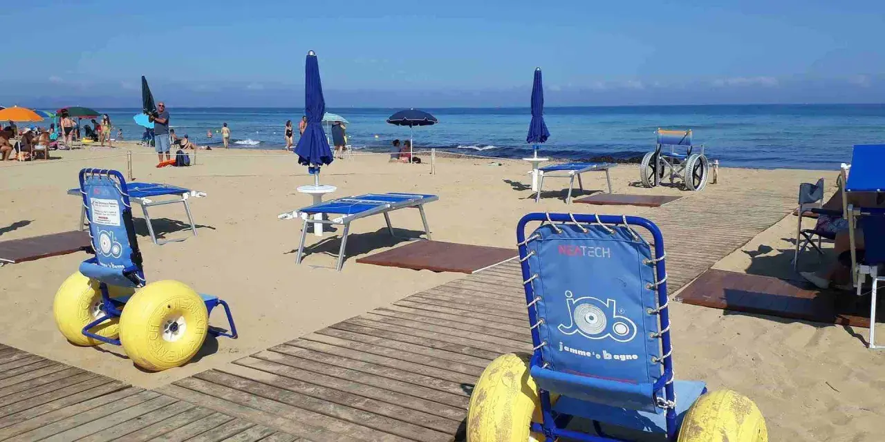 Carrozzine speciali e passerelle per vacanze per disabili con assistenza su una spiaggia attrezzata.