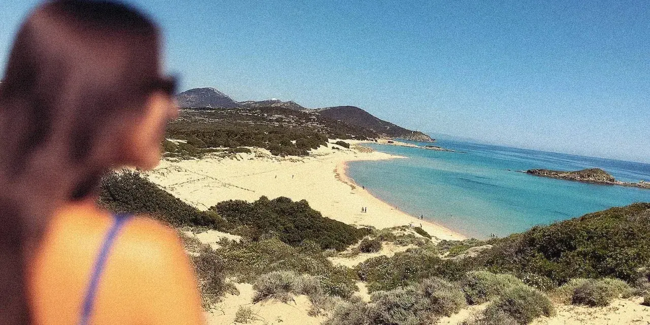 Vista mozzafiato di una spiaggia sarda, con dune sabbiose e macchia mediterranea. Perfetta per le gite in Sardegna.