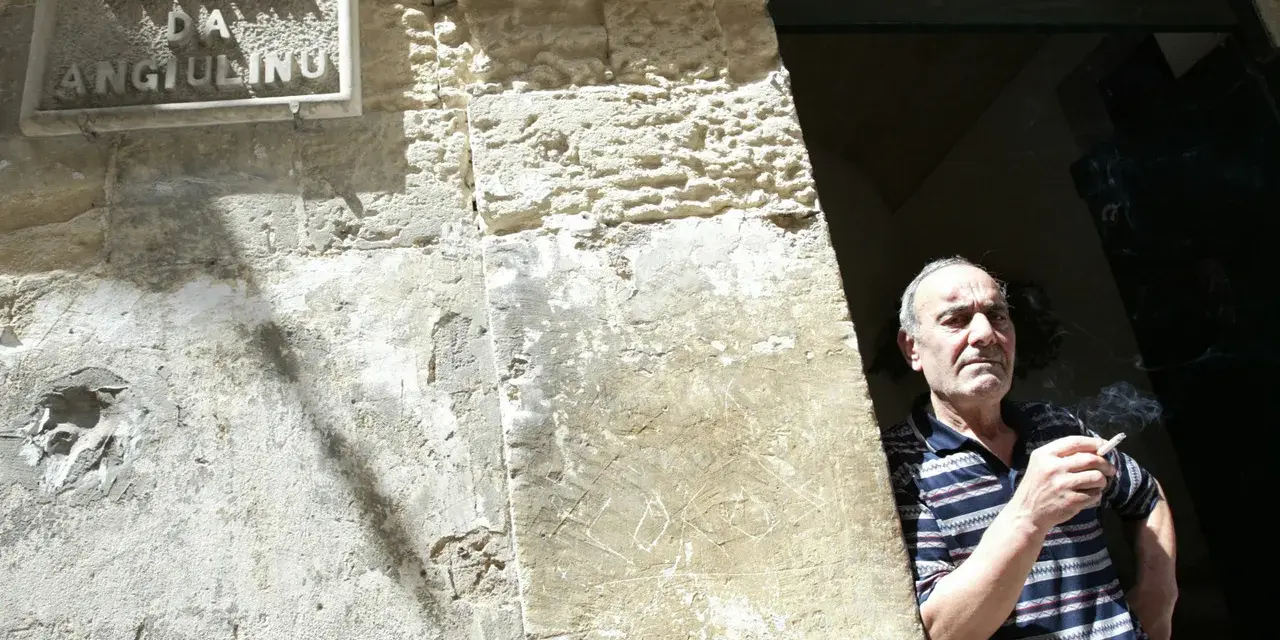 Uomo fuma davanti alla trattoria Angiolino a Lecce.
