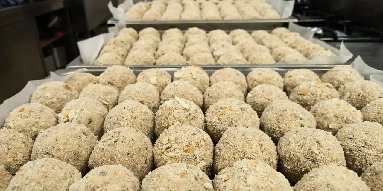 Grandi vassoi pieni di canederli dolci trentini pronti per essere cucinati.