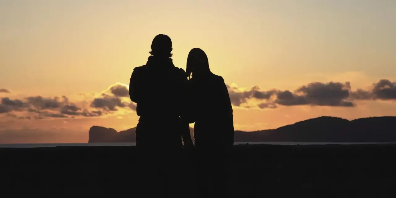 Coppia al tramonto in Sardegna, un'idea perfetta per dove andare in vacanza.