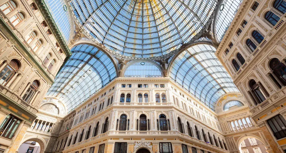 Galleria Umberto I a Napoli, un gioiello architettonico con cupola in vetro. Le differenze con la Galleria Vittorio Emanuele II di Milano sono evidenti nello stile e nei dettagli.