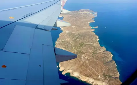 Vista aerea di Lampedusa dall'aereo, con l'ala in primo piano. Un modo per capire come arrivare a Lampedusa.