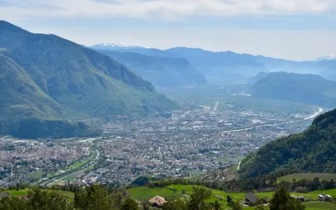 Vista panoramica di Bolzano e della valle, con montagne verdi e innevate sullo sfondo. Perfetto per scoprire cosa fare a Bolzano in un giorno.