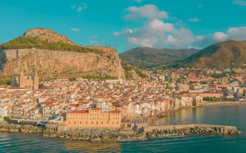 Cefalù, una delle più belle gite di un giorno da Palermo, con il suo borgo arroccato sotto la Rocca e il mare azzurro.