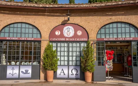 Ingresso alle catacombe di San Callisto, tra i più suggestivi siti di Roma. Due negozi di souvenir fiancheggiano l'entrata principale.