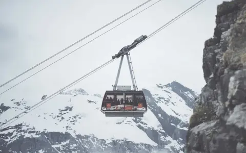 Cabina della funivia in Trentino, sospesa tra cime innevate e rocce imponenti, ideale per muoversi in un paesaggio mozzafiato.