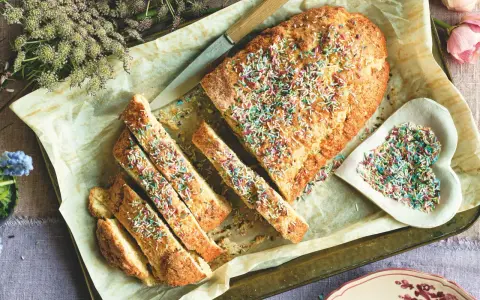 Dolce tipico romagnolo, un ciambellone soffice decorato con zuccherini colorati, pronto per essere gustato.