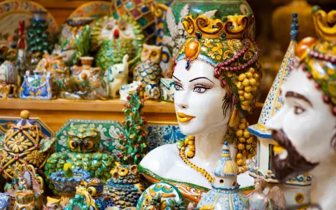 Ceramiche colorate, gufi, teste di moro e vasi: un tripudio di souvenir di viaggio che cattura l'essenza dell'artigianato locale.