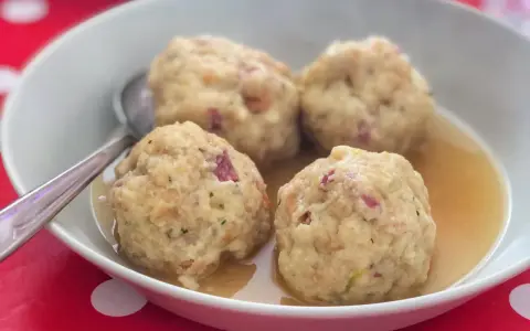 Canederli in brodo, un classico tra i piatti tipici del Trentino Alto Adige, perfetti per scoprire la curiosità culinaria della regione.